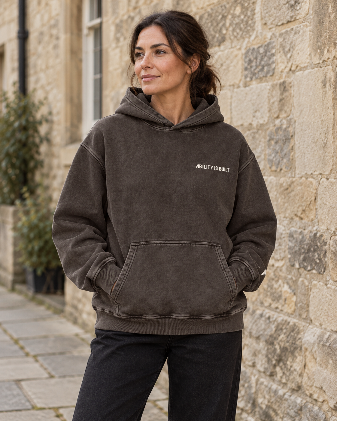 AI-generated lifestyle mockup of the AIB Dark Gray hoodie worn by an adult model