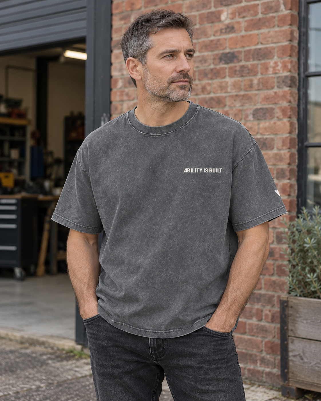 AI-generated lifestyle mockup of the AIB Pirate Gray washed T-shirt worn by an adult model